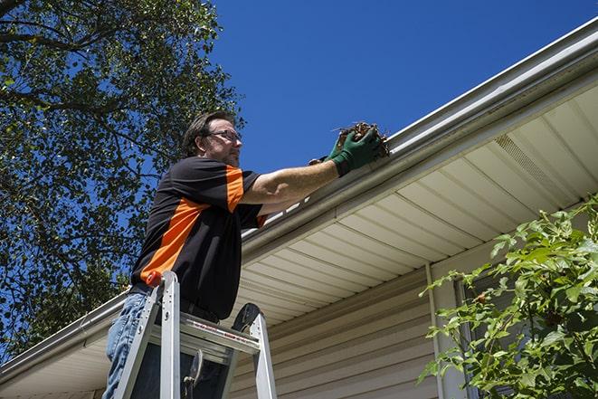 a technician replacing a section of damaged gutter in Andover